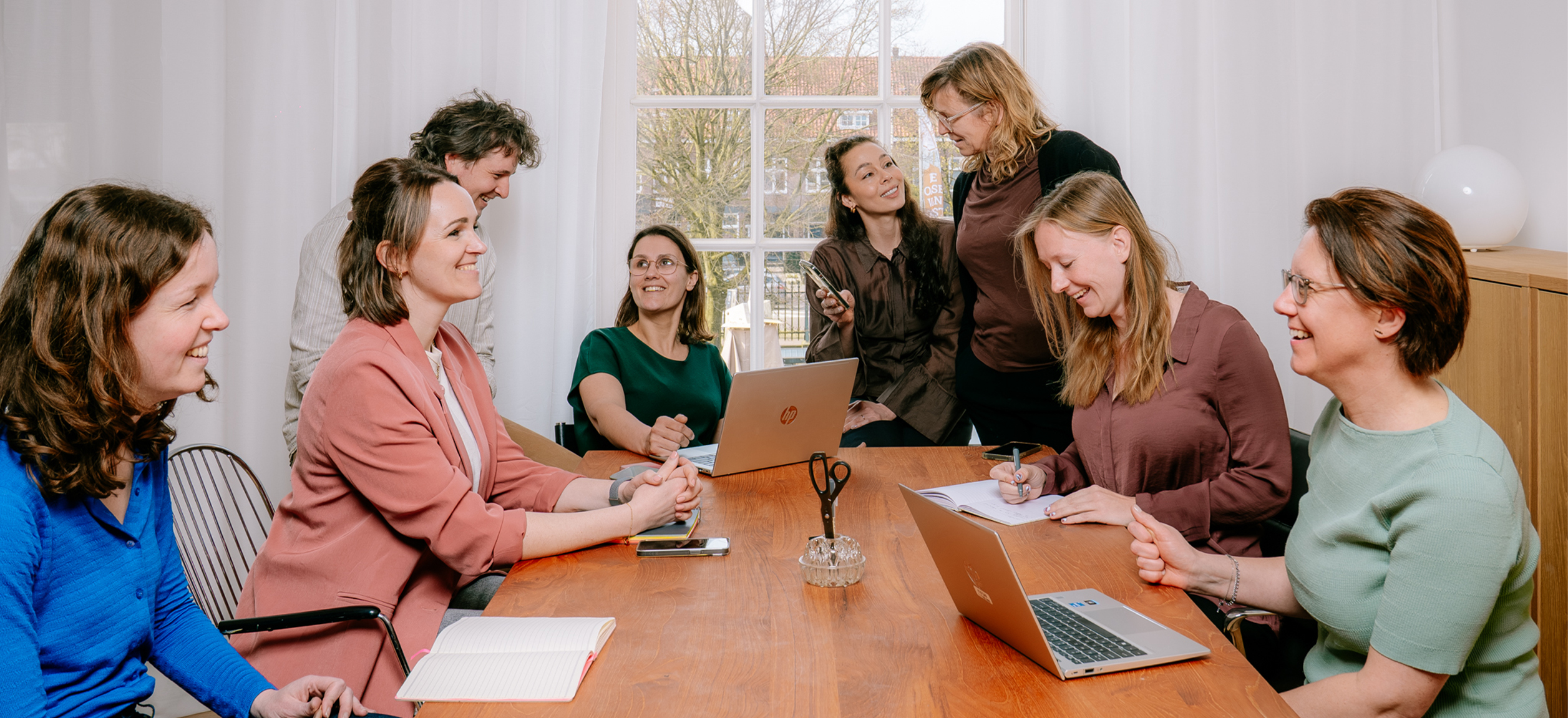 vrouw zittend in stoel met op de achtergrond een groene plant en kunst